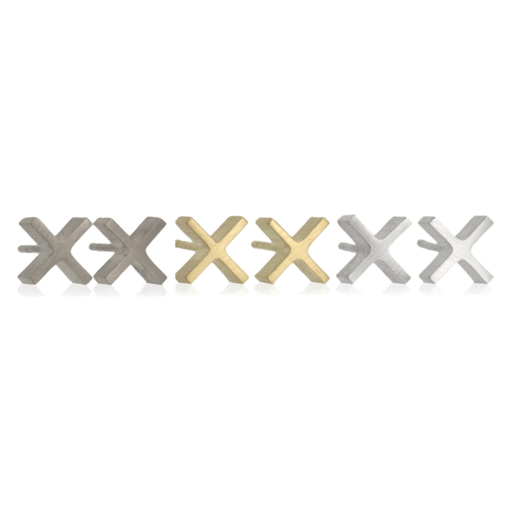 three pairs of solid gold X shaped stud earrings, black, yellow gold and silver on a white background