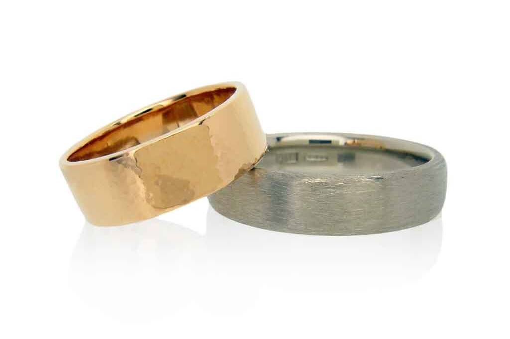 18k rose and white gold wedding bands with hammered and matte finishes on a white background.