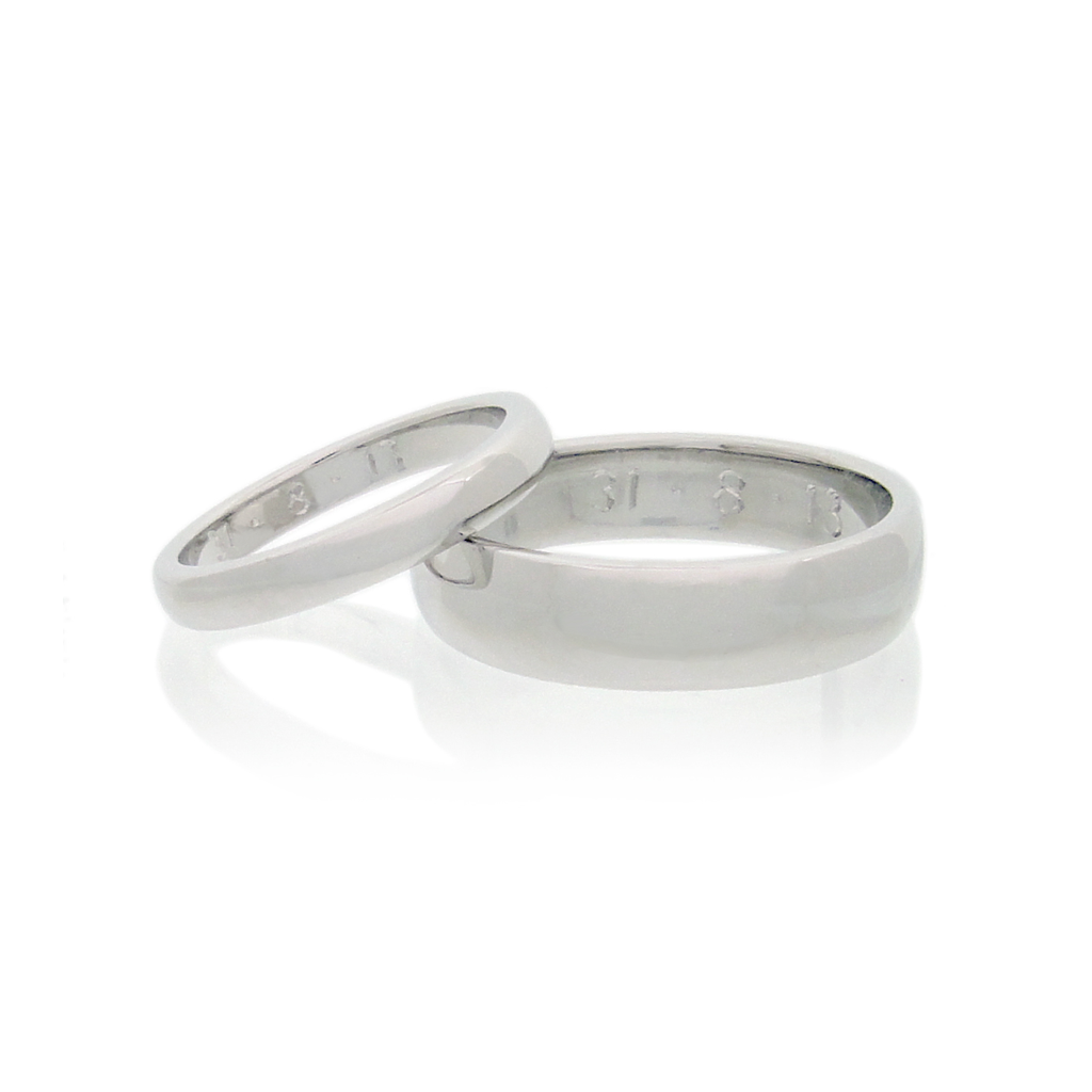 A pair of handmade wedding rings set against a white background.