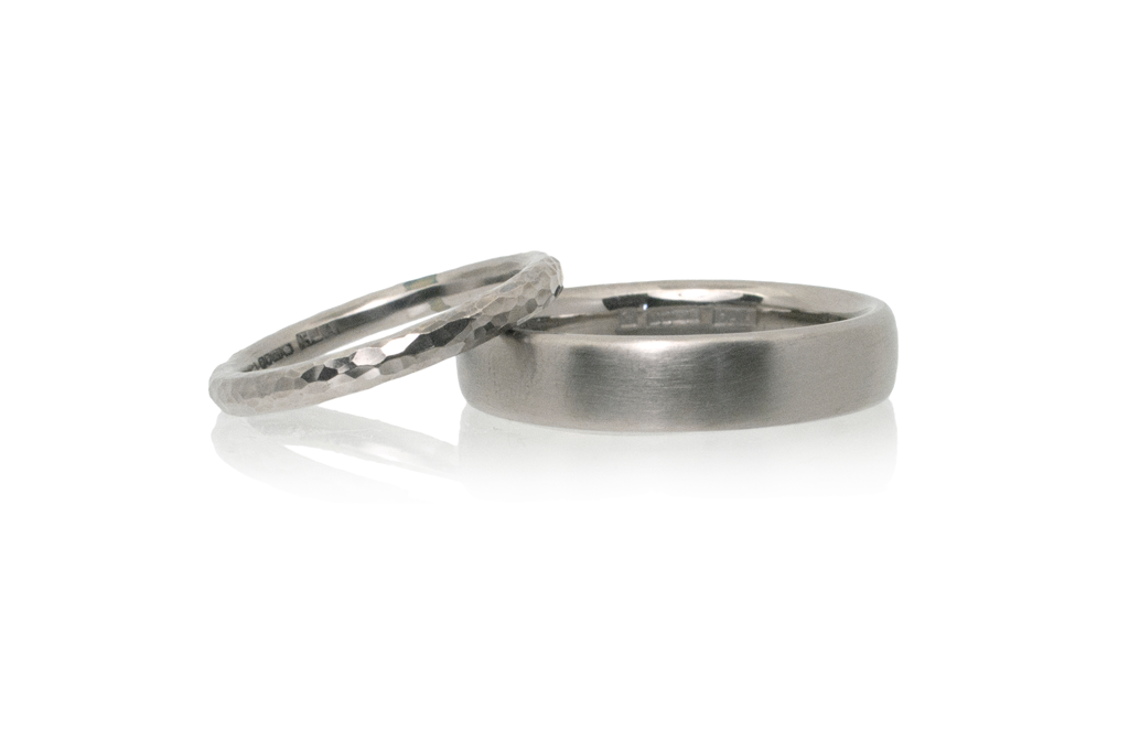 A pair of white gold wedding rings set against a white background.