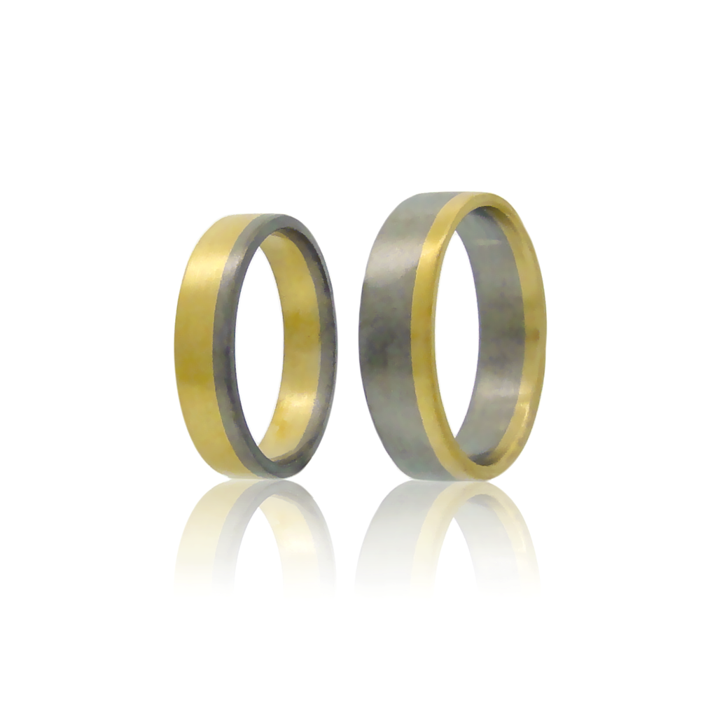 Two upright, two tone rings in yellow and white gold set against a white background.
