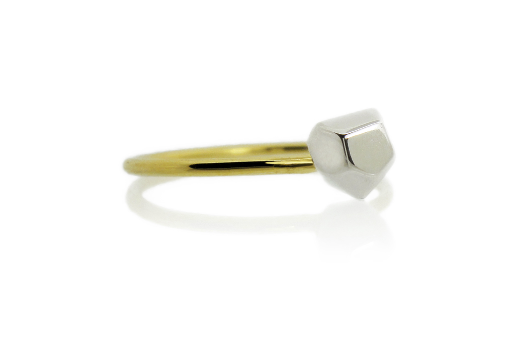 Asteroid solitaire ring. Asteroid in white gold, the band in yellow gold on a white background.