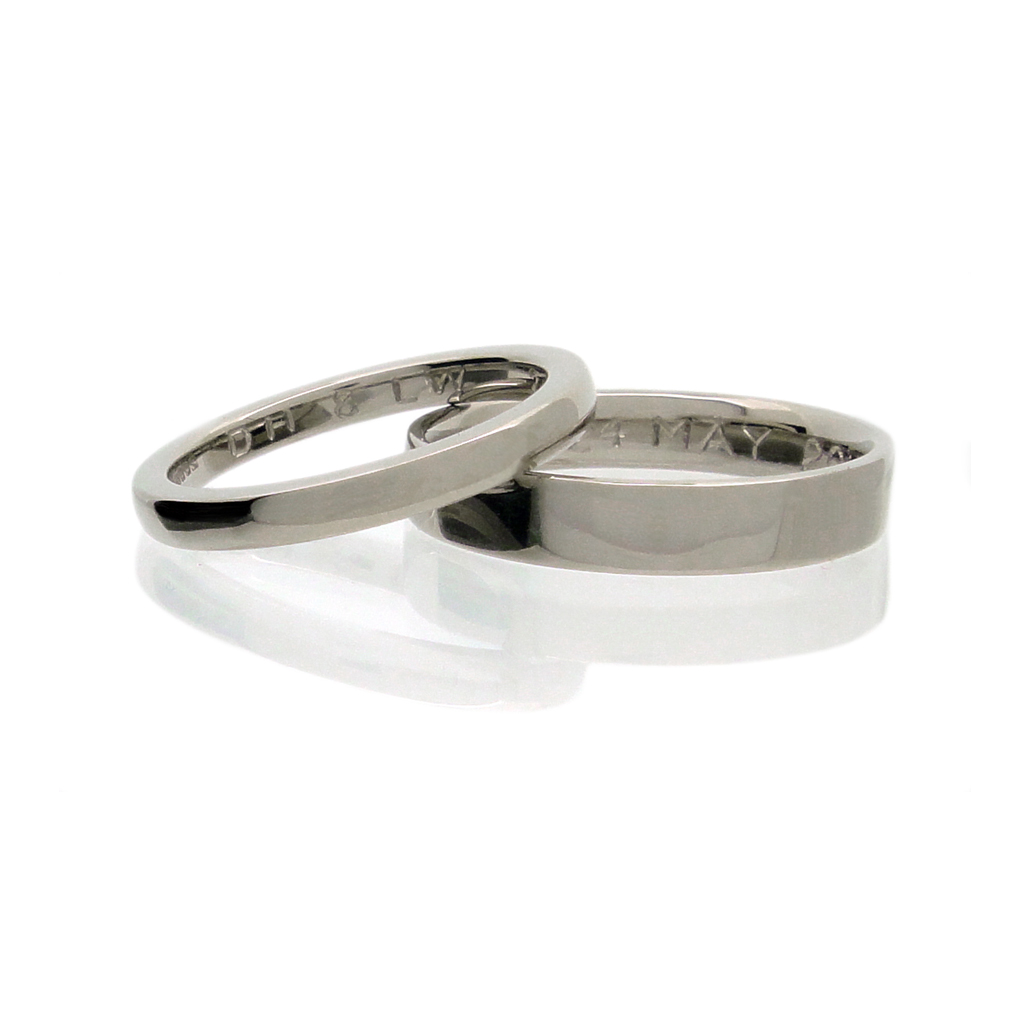 Ethical Fairtrade gold wedding rings with hand engraving on white background