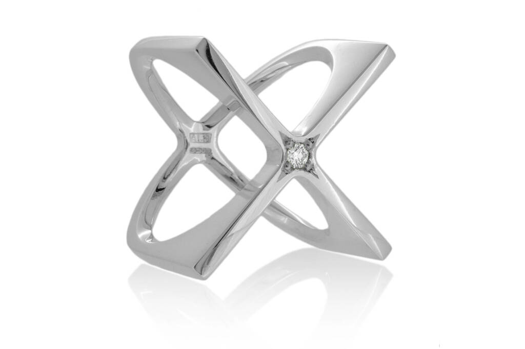 silver sculptural ring in the shape of a 3D X, with central diamond, on a white background