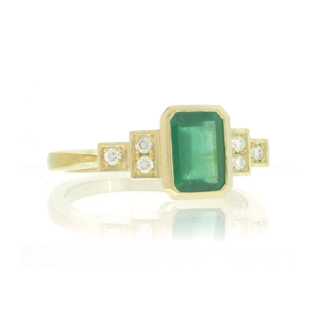 Front view of Emerald and diamond engagement ring on white background.