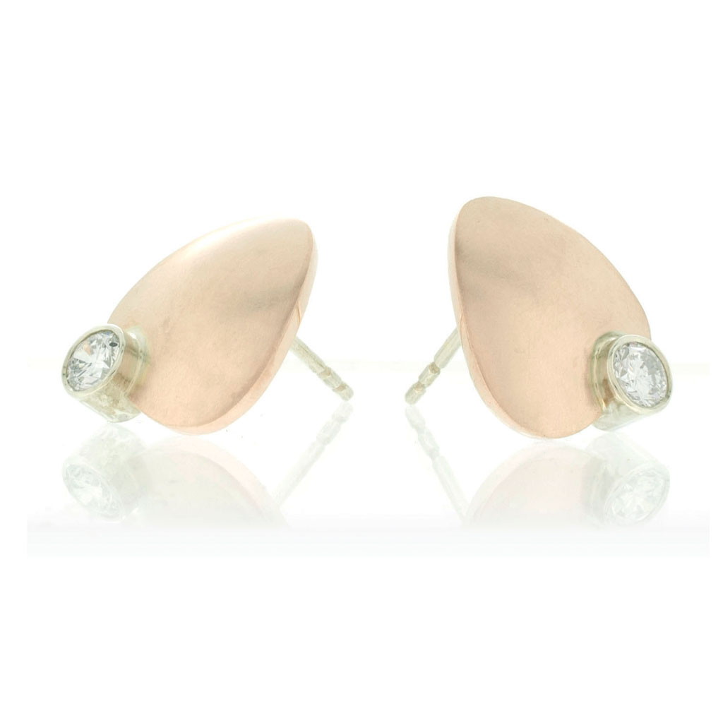 Petal shaped stud earrings in rose gold with diamonds set in contrasting white gold on white background.