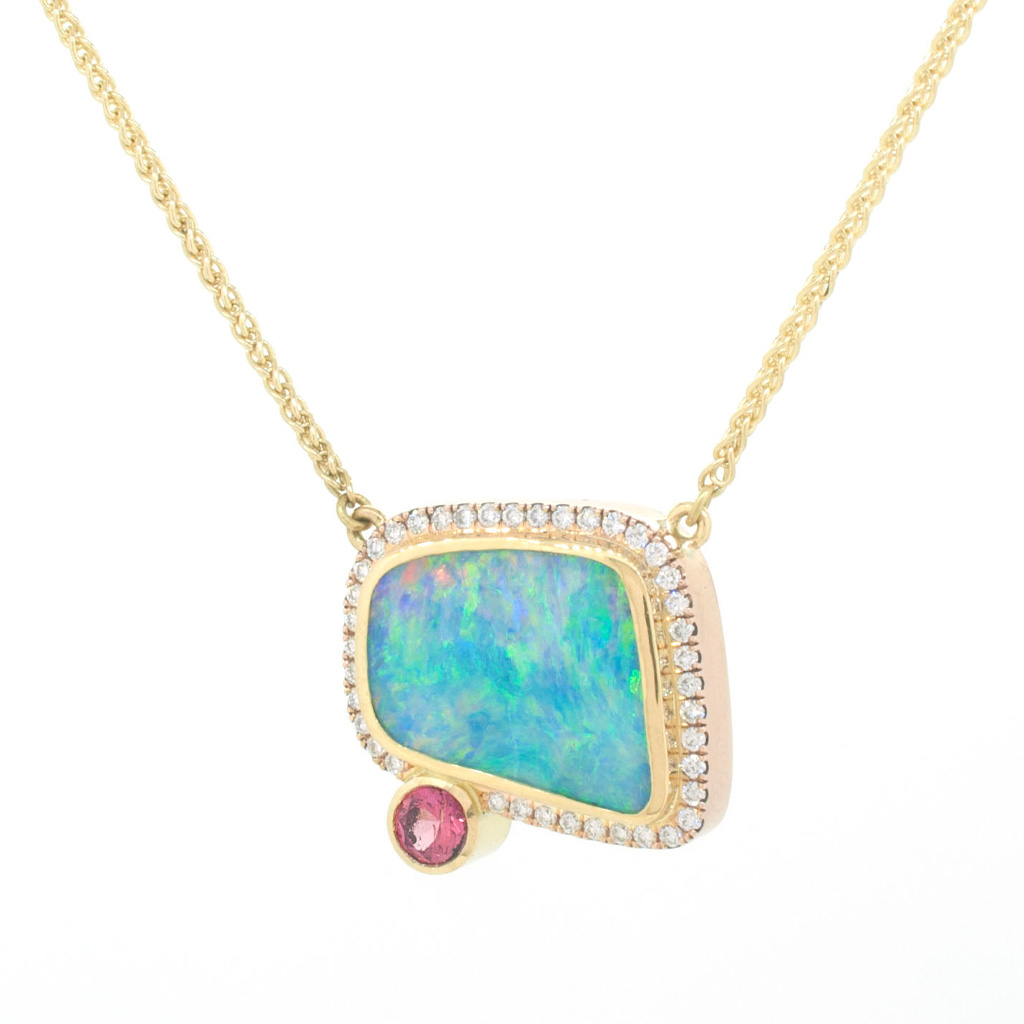 Boulder opal, diamond and padparadscha sapphire hanging on a gold chain on a white background.