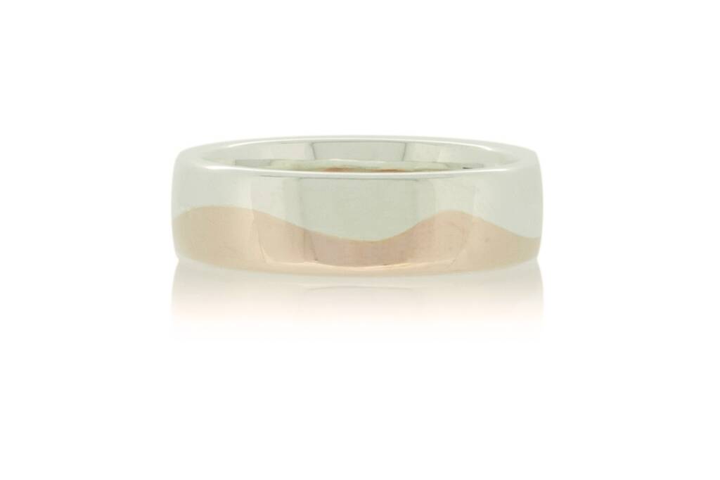 Silver and rose gold wedding band with wave design set against a white background.