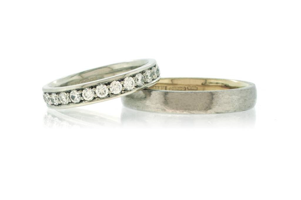 Platinum and diamond eternity ring with bi-metal platinum men's wedding ring on a white background.