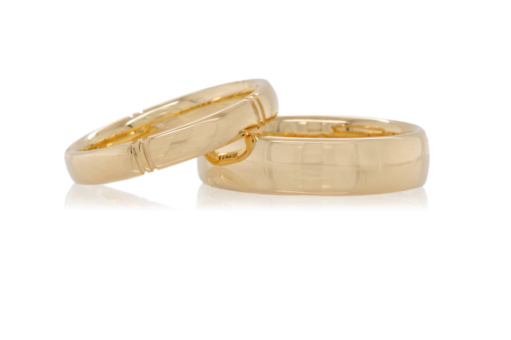 A pair of yellow gold court profile wedding rings on a white background.