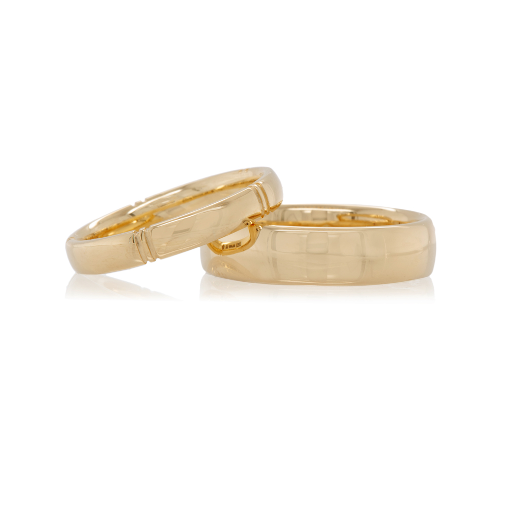 A pair of yellow gold court profile wedding rings on a white background.
