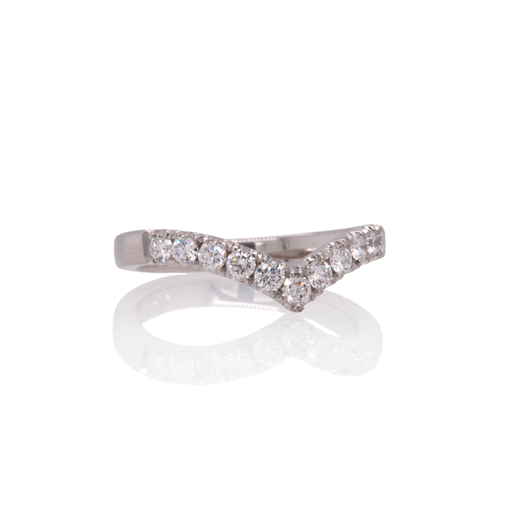 18k white gold 'wave' shaped eternity wedding ring set with baguette diamonds on a white background.