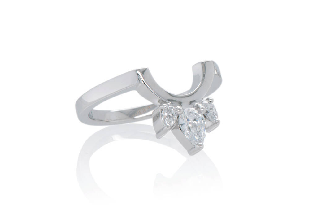 Shaped ring in white gold set 3-pear cut diamonds radiating out of a semi-circle on a white background.