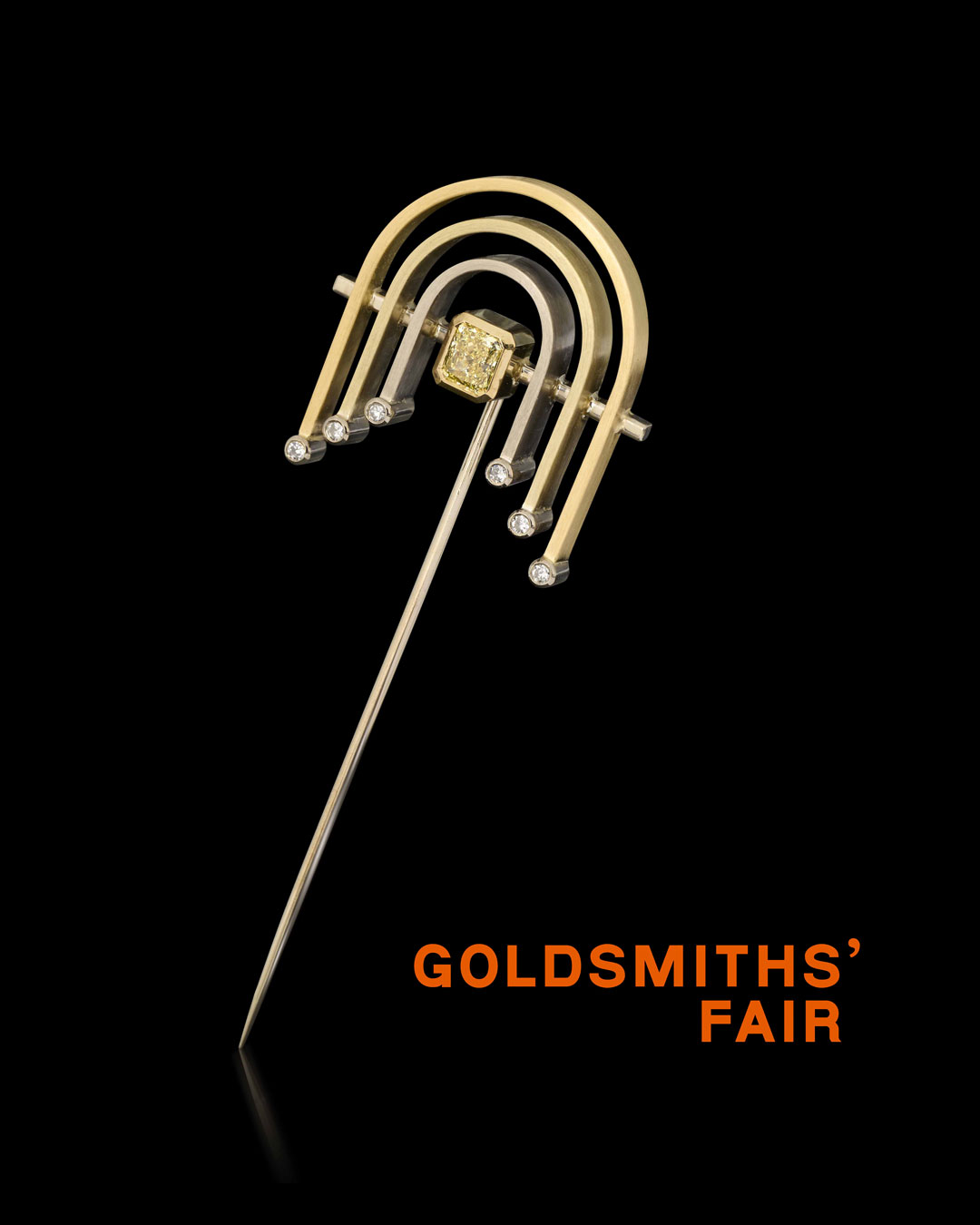 Arches pin with natural yellow and white diamonds set in an art deco inspired lapel pin on a black background with the Goldsmiths' Logo in orange in the bottom right corner.